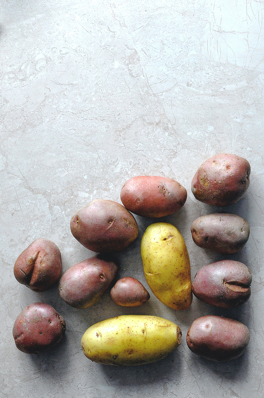 A mix of potatoes and sweet potatoes on a table top